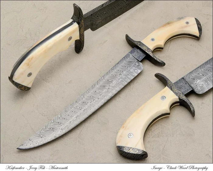 A Damascus dagger with a carved handle and a decorated pommel, on a blue ground.